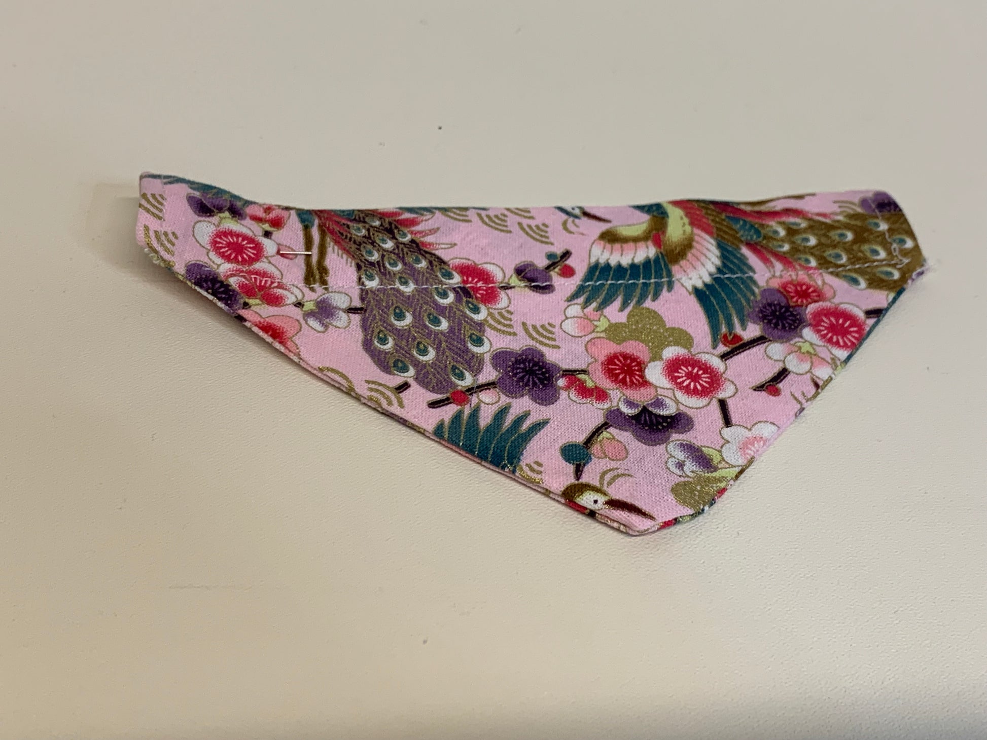 Floral and bird patterned bandana on a plain background