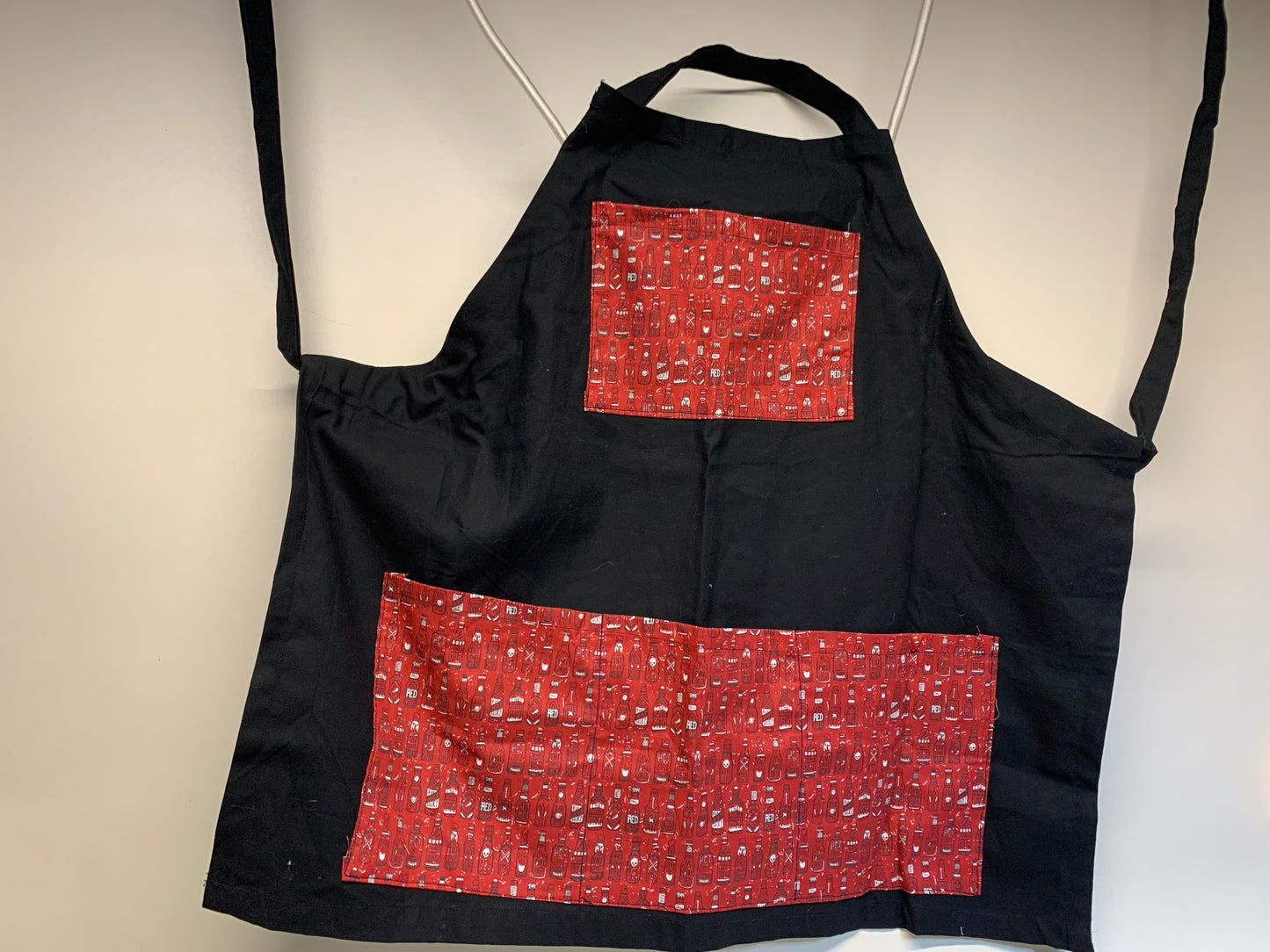 Full size Apron -Adjustable neckline. Black with Red pockets (with hot sauce bottles)