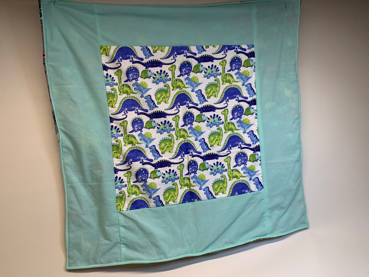 Baby Blanket - Side 1: teal blue with dinosaurs  - Side 2: Grey with dinosaurs