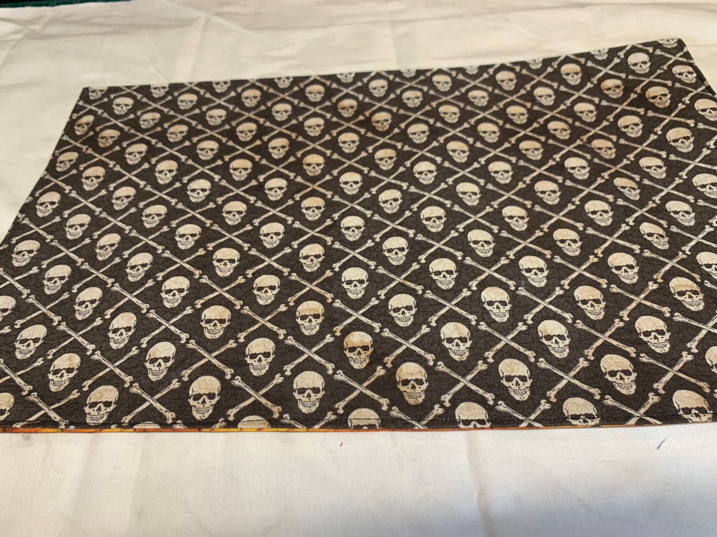 Placemat  - Skull and crossbones on one side and orange wood grain on other - 11 1/2" x 17"