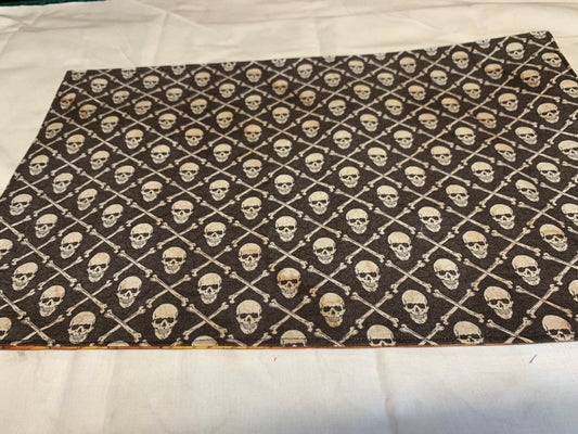 Placemat  - Skull and crossbones on one side and orange wood grain on other - 11 1/2" x 17"