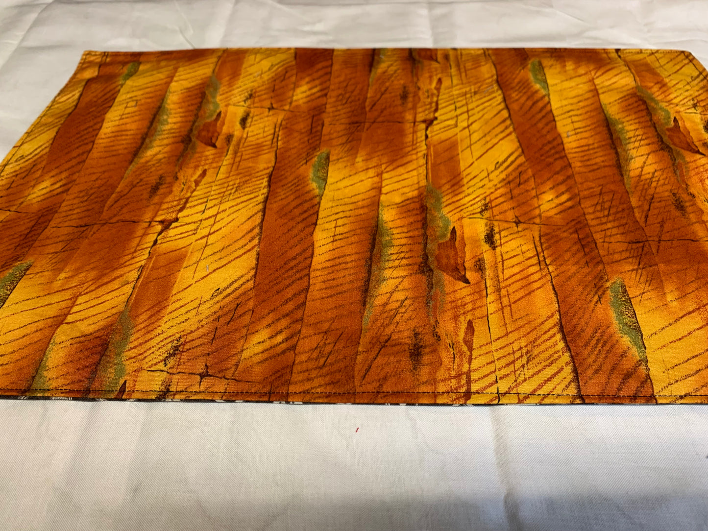 Placemat  - Skull and crossbones on one side and orange wood grain on other - 11 1/2" x 17"